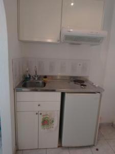 a small kitchen with a sink and a stove at Hotel Anixis Resort in Naxos Chora