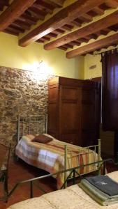 a bedroom with two beds and a stone wall at La Coccinella di Silvia e Simone in Massarosa