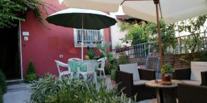 een patio met een tafel en stoelen en een parasol bij La Coccinella di Silvia e Simone in Massarosa