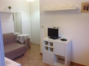 una pequeña sala de estar con TV y sofá en Appartamento Manuela, en Civitanova Marche