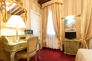a hotel room with a desk and a mirror at Hotel al Graspo de Ua in Venice