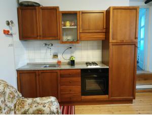 a kitchen with wooden cabinets and a sink and a stove at Il Pellicano in Rovereto +22 photos