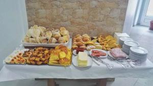 a table with many different types of bread and pastries at Fonte d' Amandos in Arganil