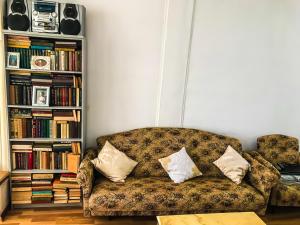 a living room with a couch and a book shelf at DEA in Zugdidi