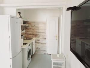 a kitchen with a white refrigerator and a washer and dryer at Bungalow 2-7 Playa del Ingles in Playa del Ingles