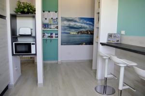 una camera con cucina con bancone e sgabelli di Tra cielo e mare a Gaeta