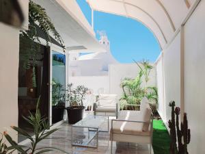 an outdoor patio with white chairs and plants at Bungalow 2-7 Playa del Ingles in Playa del Ingles