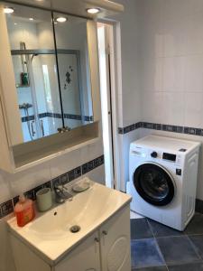 een badkamer met een wasmachine en een wastafel bij R.R. Liepaja Apartments Siguldas in Liepāja