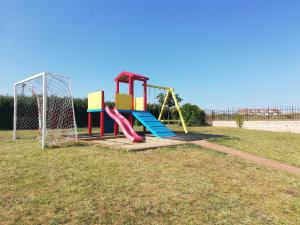 a playground with a slide in a park at DEA Pasavan Apartments in Ravda