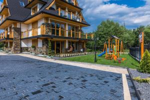 una casa con un parco giochi di fronte di Rezydencja Diamond SPA a Białka