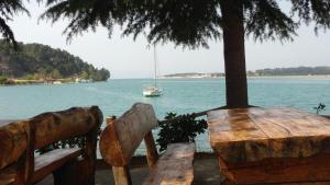 a table and chairs with a boat in the water at Villa Clara in Labinci