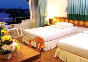 a hotel room with two beds and a table with flowers at Krabi River Hotel in Krabi town