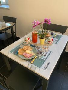 a table with a plate of food and flowers on it at Mikeme in Carrara