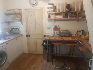 a kitchen with a counter with stools next to a sink at 69 ALBERT STREET in Saint Albans