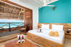a bedroom with a bed with a view of the ocean at Pili Pili Sunrise in Jambiani