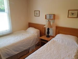 a bedroom with two beds and a lamp on a table at KEYFIELD TERRACE SERVICED APARTMENTS in Saint Albans