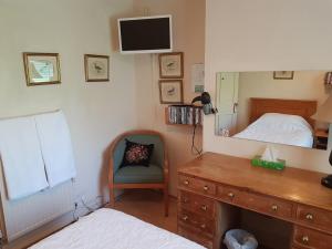 um quarto com uma cama, uma cómoda e um espelho em KEYFIELD TERRACE SERVICED APARTMENTS em Saint Albans