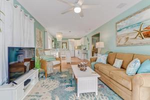 a living room with a couch and a tv at Coral Cottage Retreat in Naples