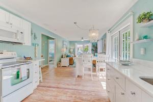 a kitchen and dining room with blue walls and white cabinets at Coral Cottage Retreat in Naples
