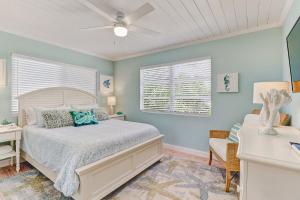 a bedroom with a bed and a ceiling fan at Coral Cottage Retreat in Naples