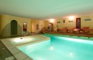 ein großer Pool mit Stühlen und Tischen in einem Gebäude in der Unterkunft Park Hotel Faver in Tremosine sul Garda