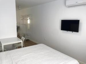 a bedroom with a bed and a flat screen tv on the wall at El Bahía Algeciras in Algeciras
