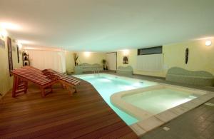 einen großen Pool mit zwei Stühlen und einem Tisch in der Unterkunft Park Hotel Faver in Tremosine sul Garda