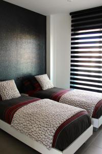 a bedroom with two beds and a window at PENTHOUSE OASIS BEACH in Playas de Orihuela