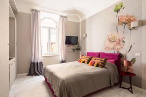 een slaapkamer met een bed met roze en gele kussens bij Apt.Prati L.T. (Vatican and center) in Rome
