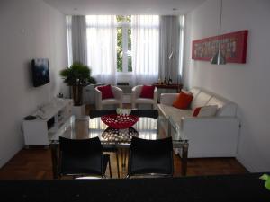 sala de estar con mesa de cristal y sillas en Apartamento Luxo Ipanema, en Río de Janeiro