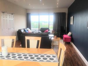 ein Wohnzimmer mit einem Sofa und einem Tisch in der Unterkunft 5 Bedroom Central Penthouse Apartment in Edinburgh