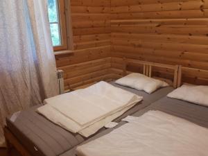a room with two beds in a log cabin at Коттедж в Финляндии (Тохмаярви) in Tohmajärvi