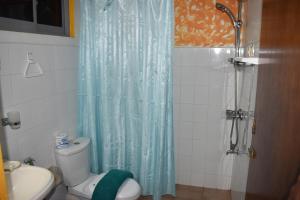 y baño con cortina de ducha azul y aseo. en Whitepearl Beach, en Hikkaduwa