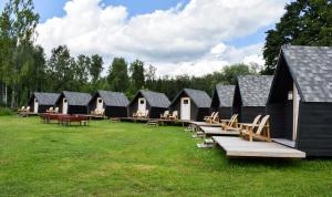 a row of black cabins with tables and benches at Chill Up in Vecpiebalga