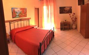 B&B Da Felice في سيرينو: غرفة نوم مع سرير مع لحاف احمر