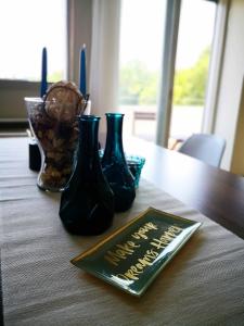 a table with three vases and a menu on it at The Bridge-House Apartment in Nicosia