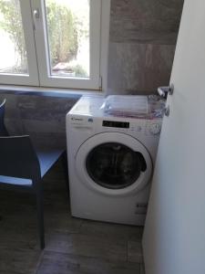 eine Waschmaschine in einem Zimmer mit Fenster in der Unterkunft La casa di Beppe c cir D1135 in Lanzo dʼIntelvi