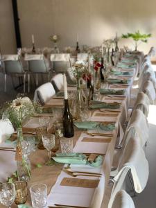 a long table with white napkins and wine bottles at 7 Bedrooms Horse Farm near Skagen in Jerup