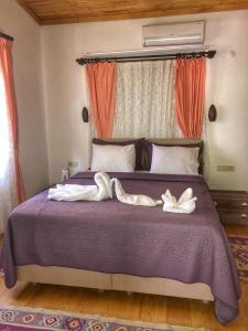 zwei Schwäne sitzen auf einem lila Bett in der Unterkunft İpek Apart Hotel in Cıralı