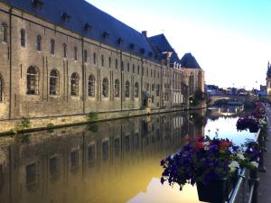 ヘントにあるstudio medieval city center at river de Leieの運河沿いに花が咲く建物