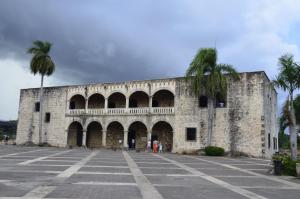 a large stone building with palm trees in front of it at Canapalma Zona Colonial in Santo Domingo