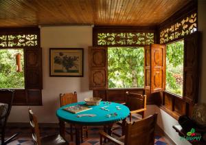 ein Esszimmer mit einem blauen Tisch und einigen Fenstern in der Unterkunft El Laurel Finca Agroturistica in Quimbaya
