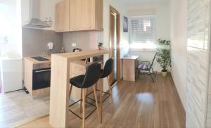 a small kitchen with a counter and two stools in it at Penthouse Spudic Karlovac in Karlovac