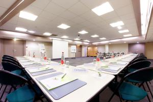 una gran sala de conferencias con una mesa larga con sillas en Campanile Paris Est - Porte de Bagnolet, en Bagnolet