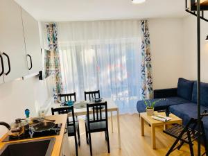 a living room with a blue couch and a table at Wojtecki Apartamenty in Pobierowo