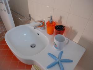a bathroom sink with two starfish and a cup on it at Hotel Liliana in Varigotti