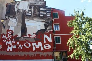 un murale sul lato di un edificio rosso di Tramonto a Mele