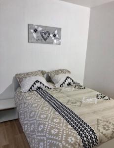 埃佩爾奈的住宿－Appartement Aventure à Épernay，卧室内的一张床铺,墙上有两颗心
