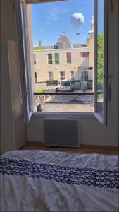 una camera da letto con finestra affacciata su un edificio di Appartement Aventure à Épernay a Épernay