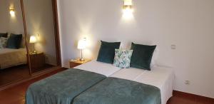 a bedroom with a large bed with green pillows at Dona Ana Guesthouse in Lagos